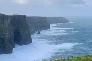 Photo of the Cliffs of Moher as massive waves break at their base