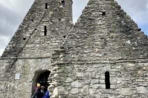 Photo of blind travelers exploring ruins of an ancient Irish monastery